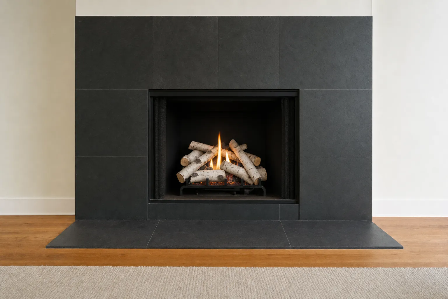 Design visualization, after: a fireplace with a dark slate surround with white birch-style gas logs in a deep black firebox
