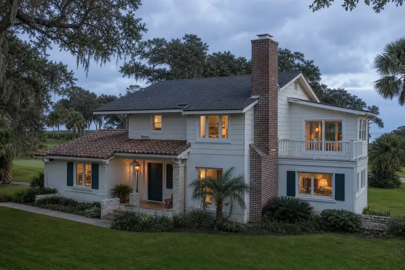 A 1980s coastal contemporary house with lap siding with a brick chimney with a metal cap and neat mortar joints; illustrative image