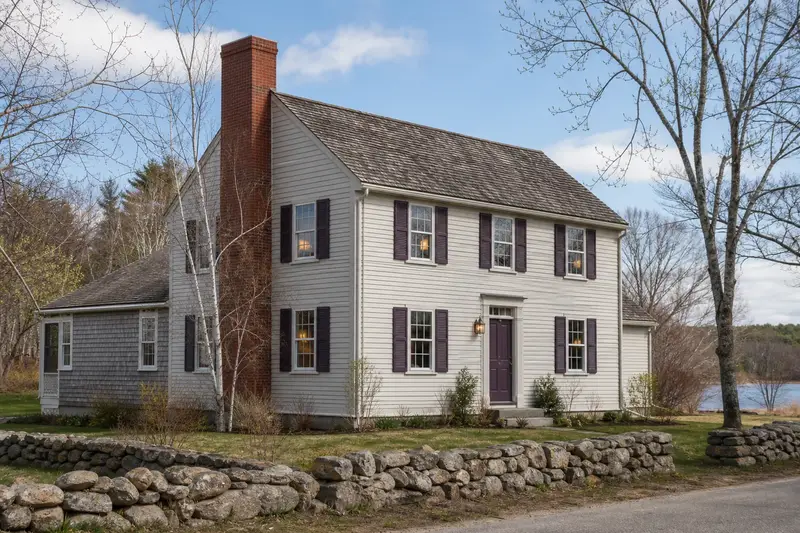 A 1940s clapboard colonial with a red brick chimney with a concrete crown of even red brick; illustrative image