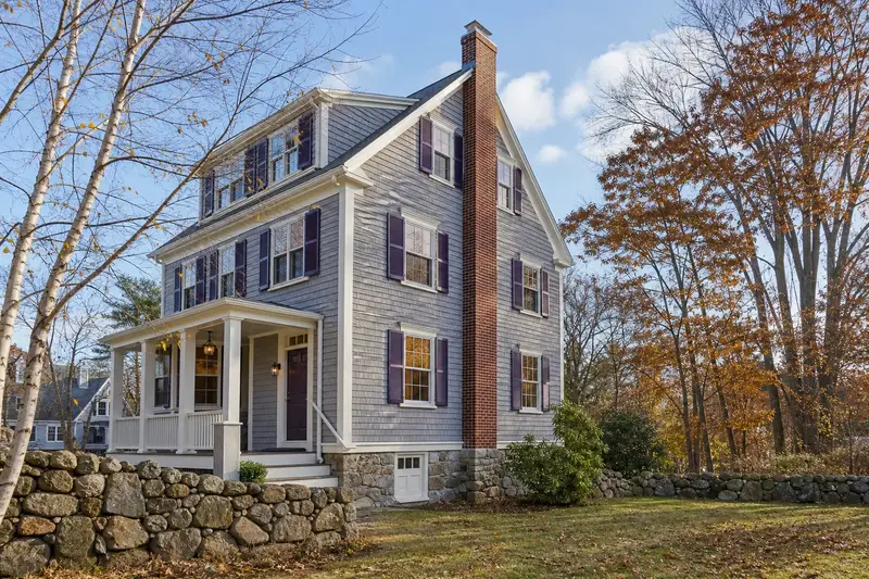 A 1940s triple-decker house with a tall brick chimney on a steep gable roof and neat mortar joints; illustrative image