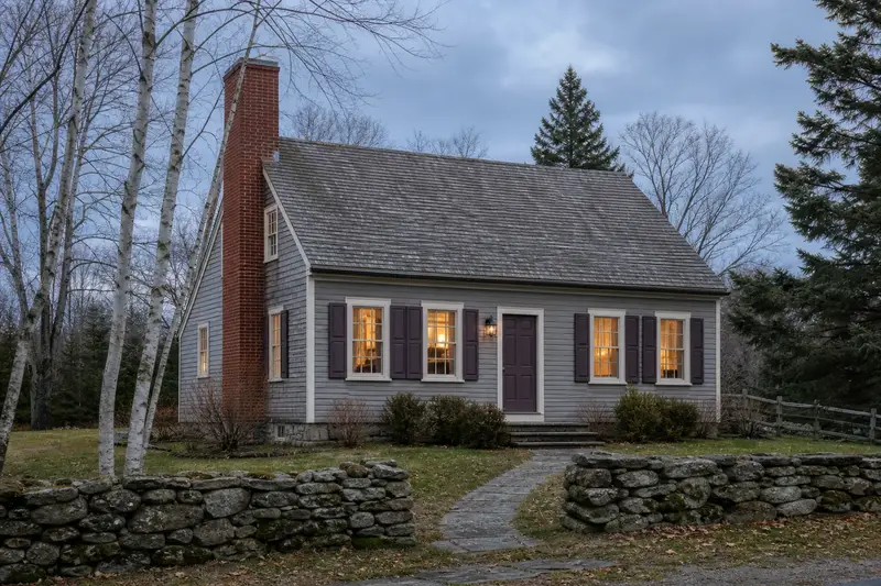A 1950s saltbox house with a red brick chimney with a concrete crown of even red brick; illustrative image