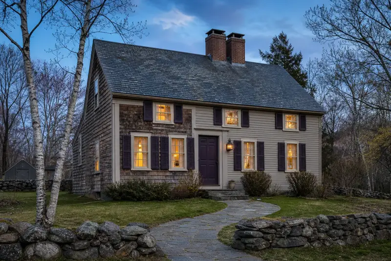 A 1950s saltbox house with a two-flue brick chimney on a slate roof and neat, even mortar joints; illustrative image