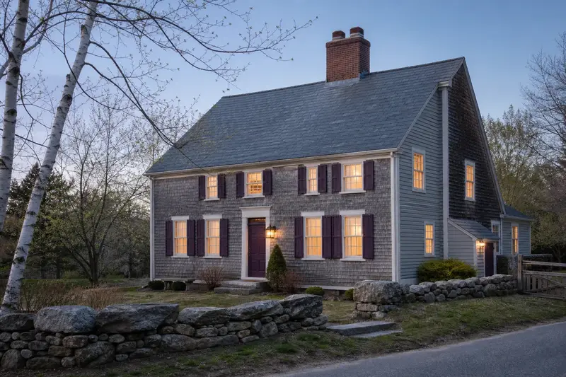 A 1940s saltbox house with a two-flue brick chimney on a slate roof rising above the roof; illustrative image