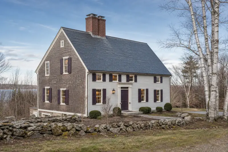 A 1950s saltbox house with a two-flue brick chimney on a slate roof and neat, even mortar joints; illustrative image