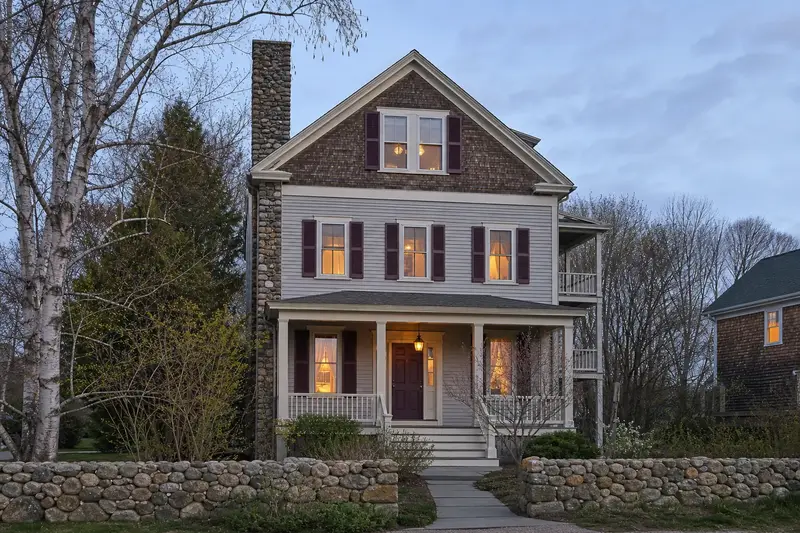 A 1950s triple-decker house with a stone masonry chimney and neat mortar joints; illustrative image