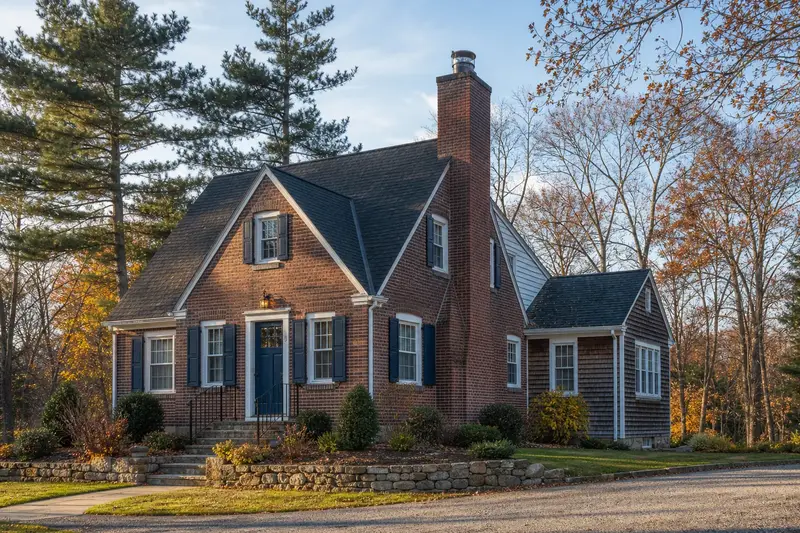 A 1940s brick bungalow with a tall brick chimney on a steep gable roof fitted with a stainless steel liner cap; illustrative image