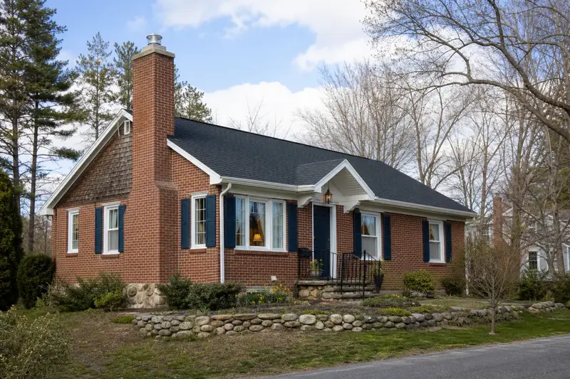 A 1950s brick bungalow with a red brick chimney with a concrete crown fitted with a stainless steel liner cap; illustrative image