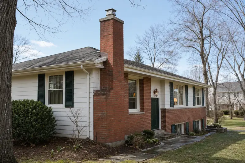 A 1960s split-level house with a red brick chimney with a concrete crown and a stainless steel cap; illustrative image