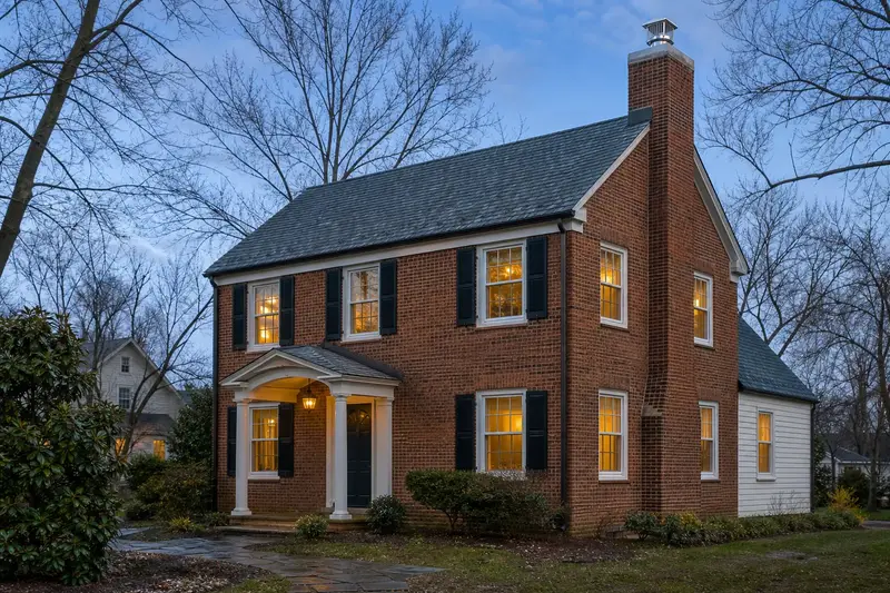A 1930s brick two-story house with a red brick chimney with a concrete crown topped by a new stainless steel cap; illustrative image