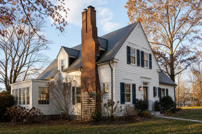A 1940s steep-gabled frame house with a two-flue brick chimney on a slate roof rising above the roof; illustrative image