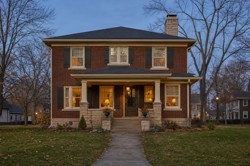 A 1950s brick foursquare house with a stone masonry chimney rising above the roof; illustrative image
