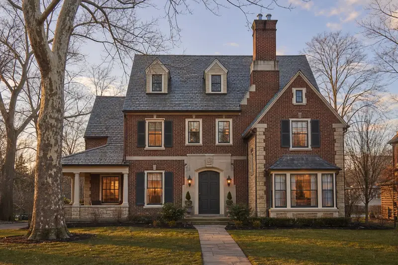 A 1920s brick-and-sandstone house with a two-flue brick chimney on a slate roof topped by a new stainless steel cap; illustrative image