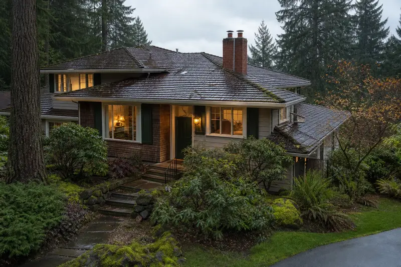 A 1990s Northwest contemporary house with wide eaves after a heavy rain with a two-flue brick chimney on a mossy shingle roof, wet roofs and clear gutters; illustrative image
