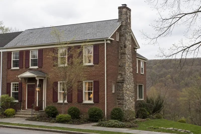 A 1940s brick rowhouse with a stone masonry chimney and a tidy front walk; illustrative image