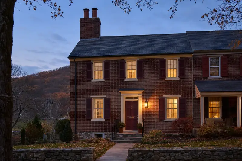 A 1940s brick rowhouse with a two-flue brick chimney on a slate roof and neat, even mortar joints; illustrative image