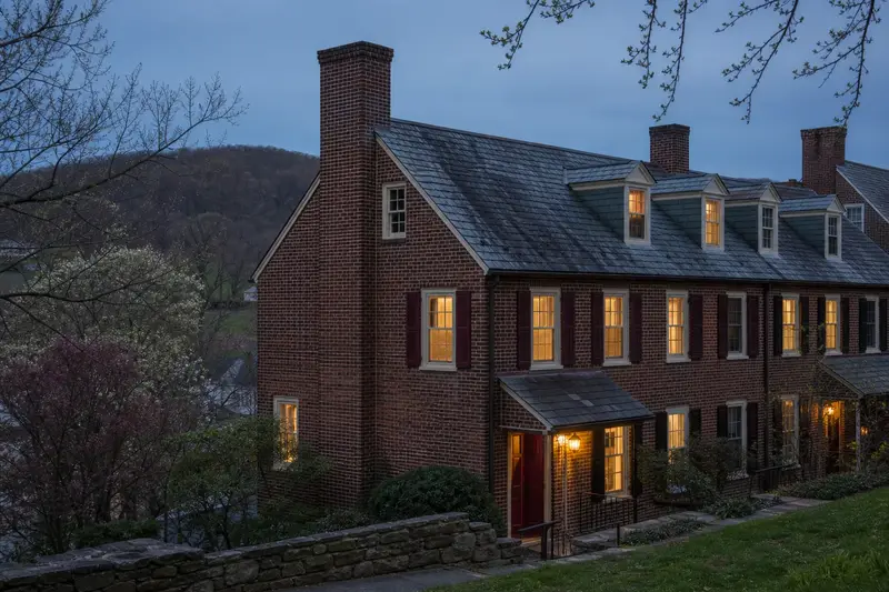 A 1940s brick rowhouse with a tall brick chimney on a steep gable roof and neat mortar joints; illustrative image