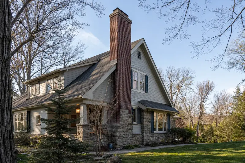 A 1940s Craftsman house with a tall brick chimney on a steep gable roof and neat, even mortar joints; illustrative image