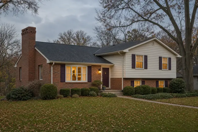 A 1980s split-level house with brick and siding with a brick chimney with corbelled top courses of even red brick; illustrative image