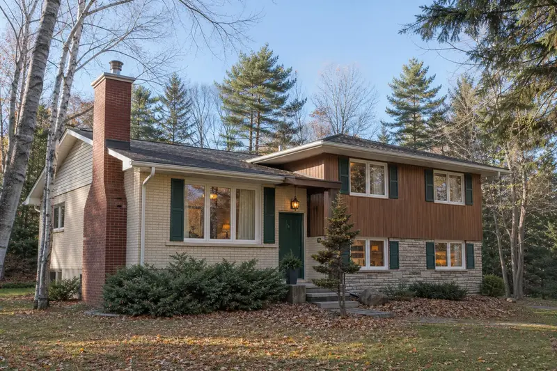 A 1960s split-level house with a red brick chimney with a concrete crown and a stainless steel cap; illustrative image