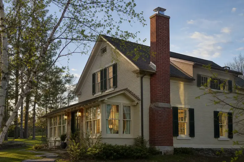 A 1920s pale cream-brick house with a red brick chimney with a concrete crown topped by a new stainless steel cap; illustrative image