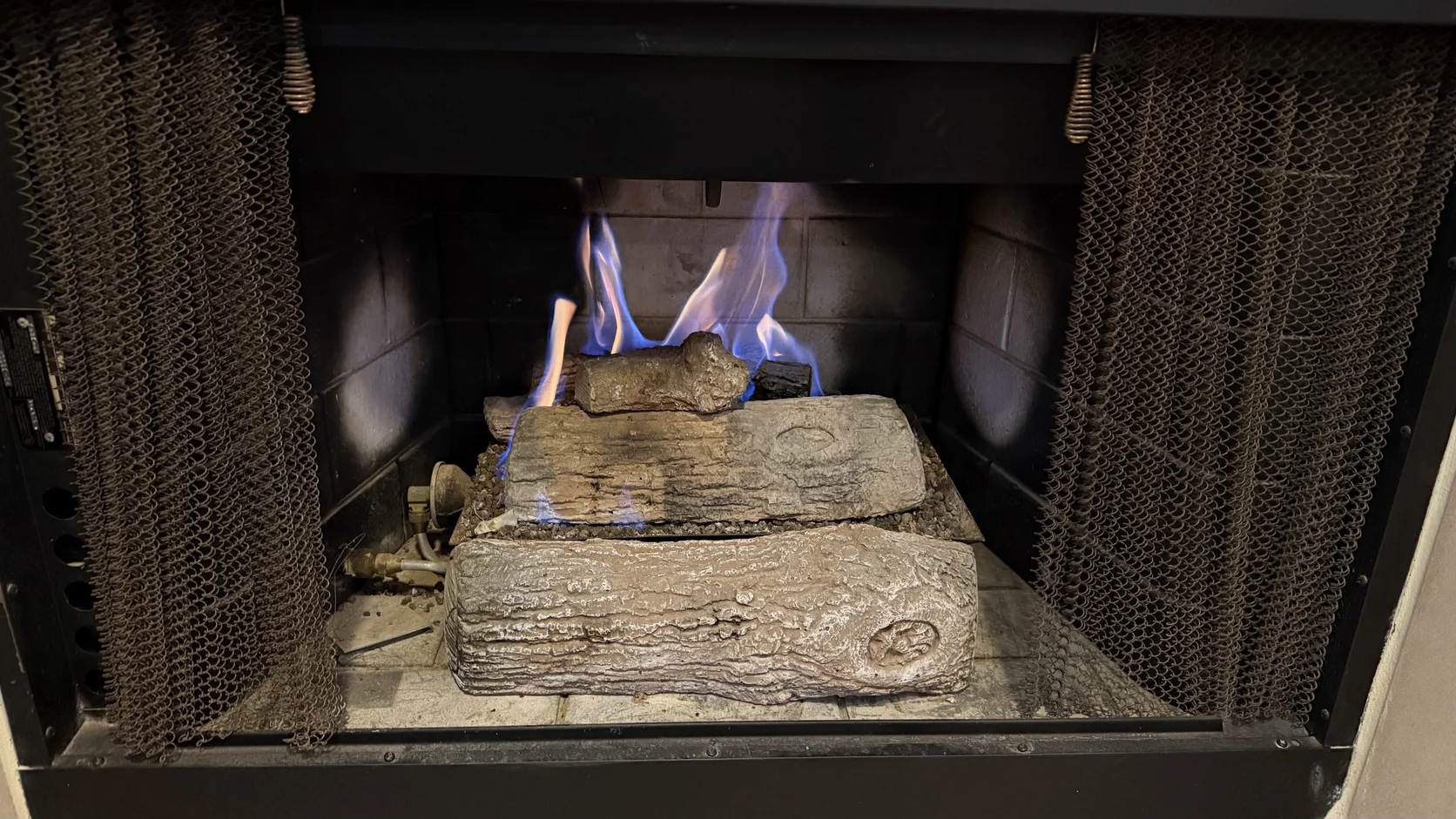 Gas logs burning with blue flame in a firebox