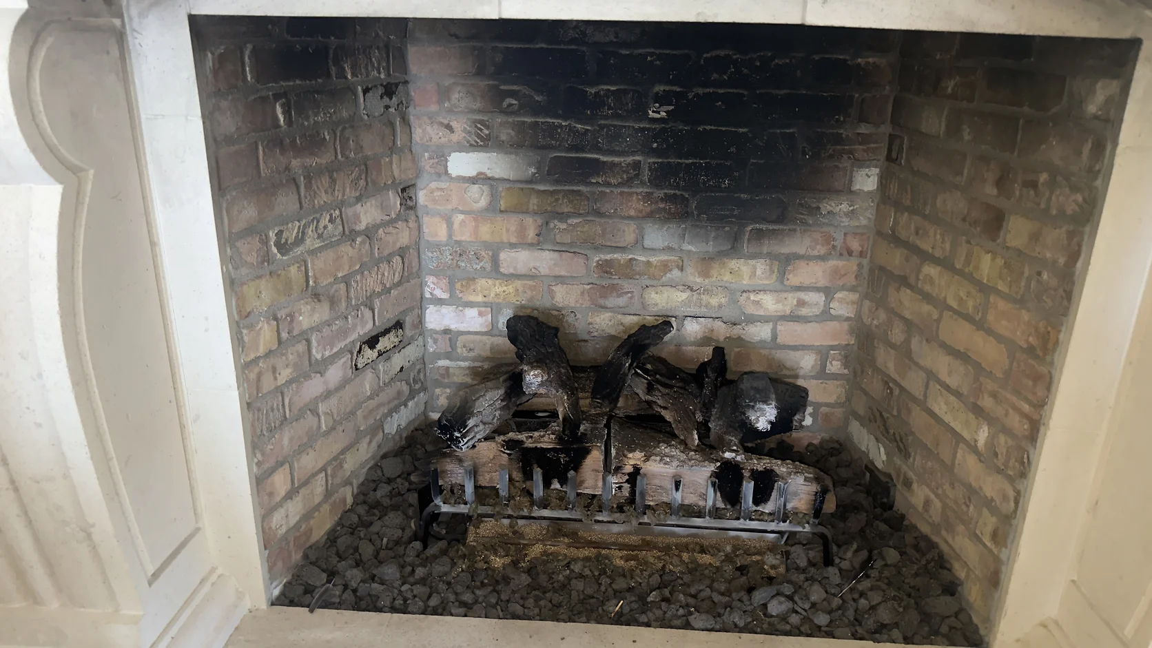 Soot-stained brick firebox with a log set