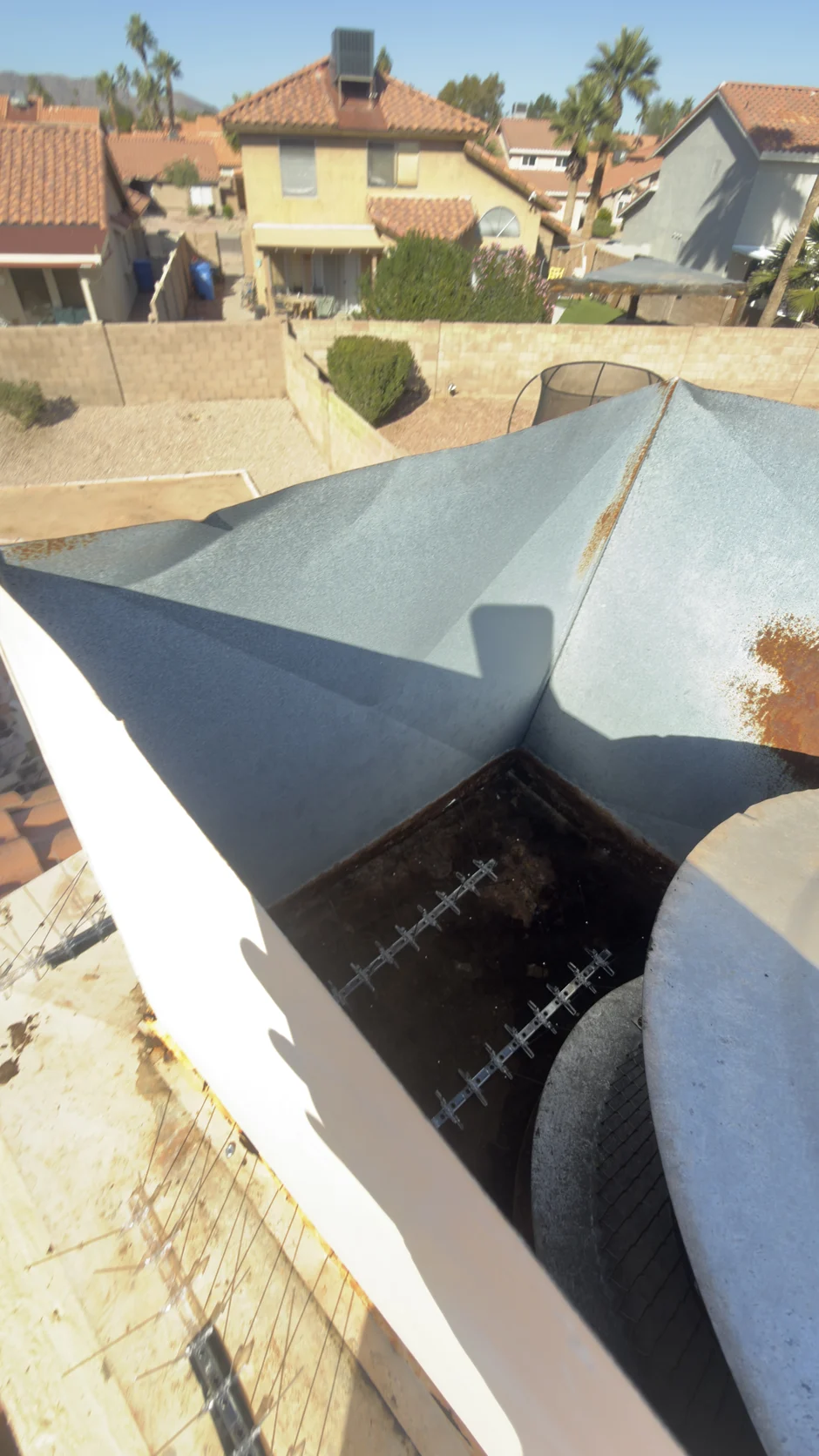 Close view of a metal chase shroud, with tile roofs behind