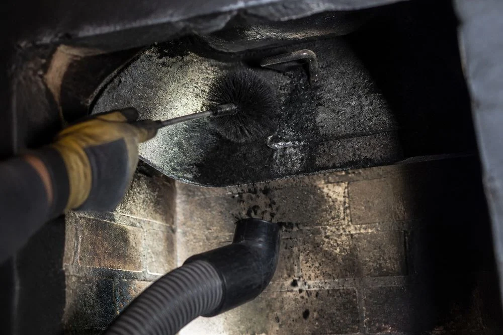 Brush hose inside a creosote-coated flue; illustrative image