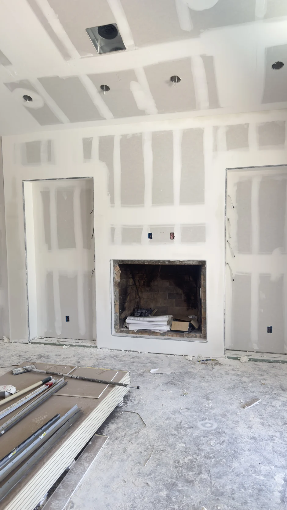 Fireplace wall under construction with bare drywall