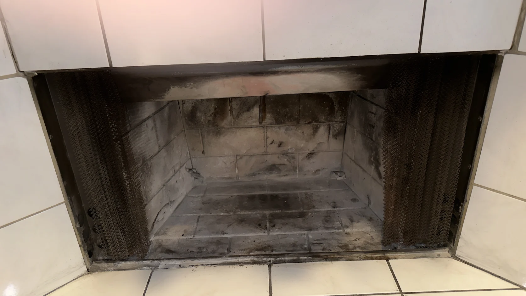 Empty, cleaned metal firebox with a mesh screen
