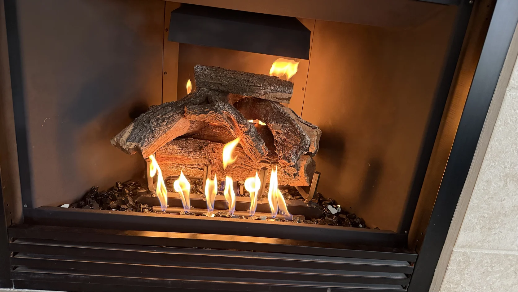 Gas logs burning in a metal firebox