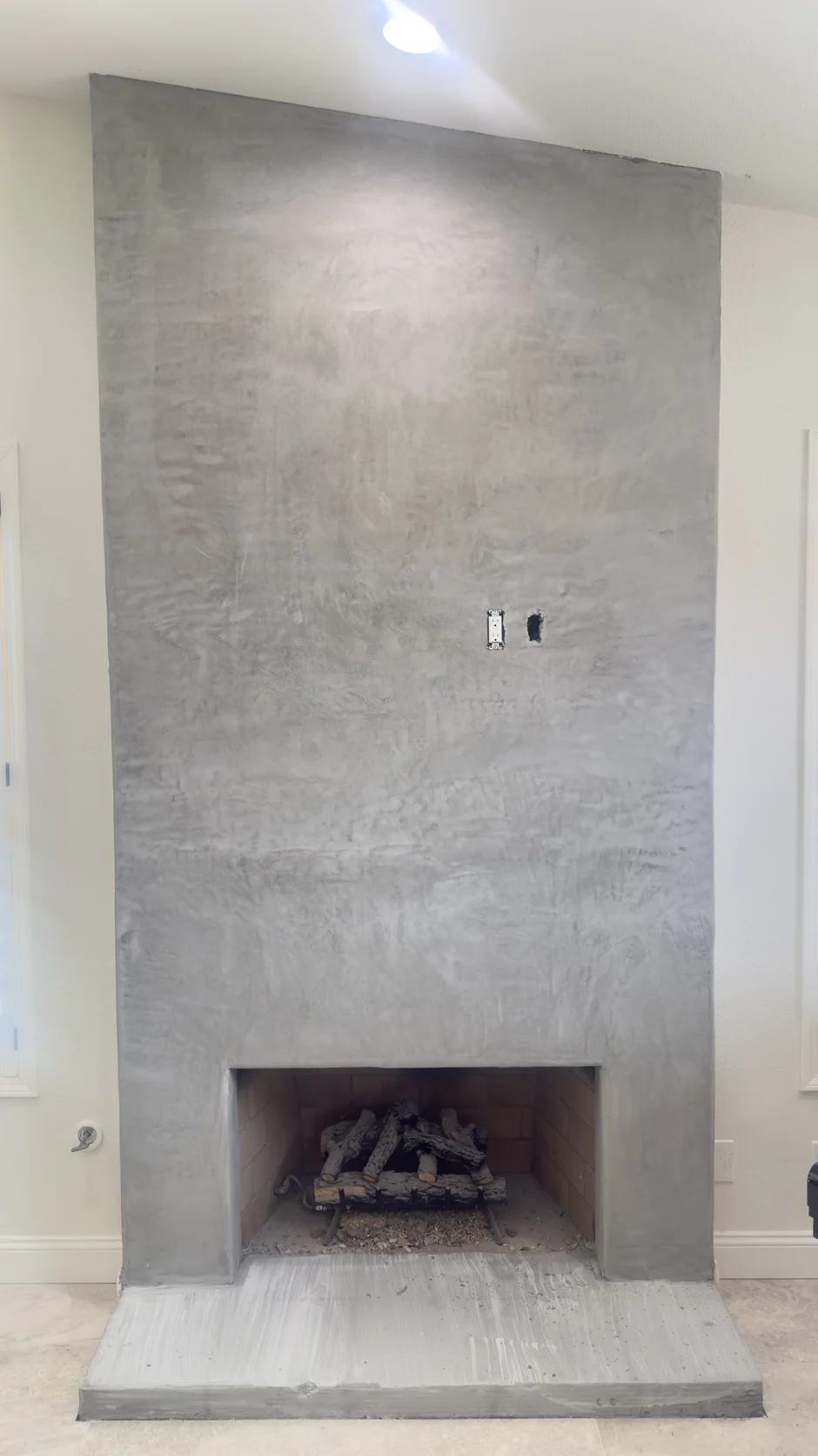 Grey plaster fireplace wall with a small firebox
