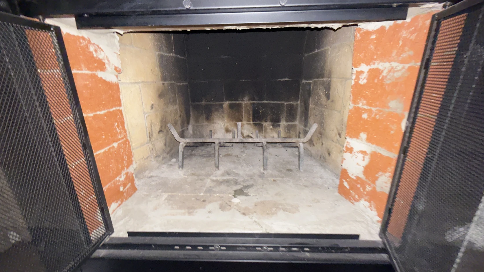 Masonry firebox stripped to bare brick with the damper open