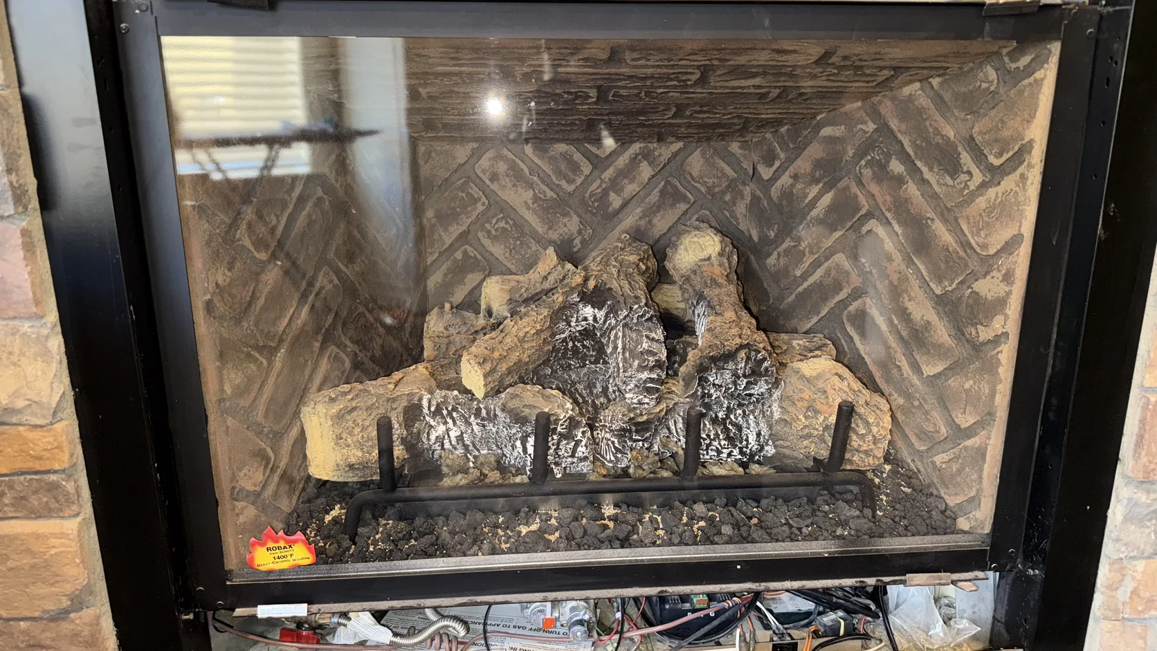 Ceramic logs in a herringbone-lined firebox