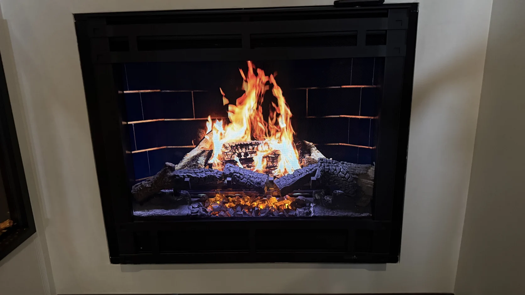 Lit fireplace insert with blue-tipped flames