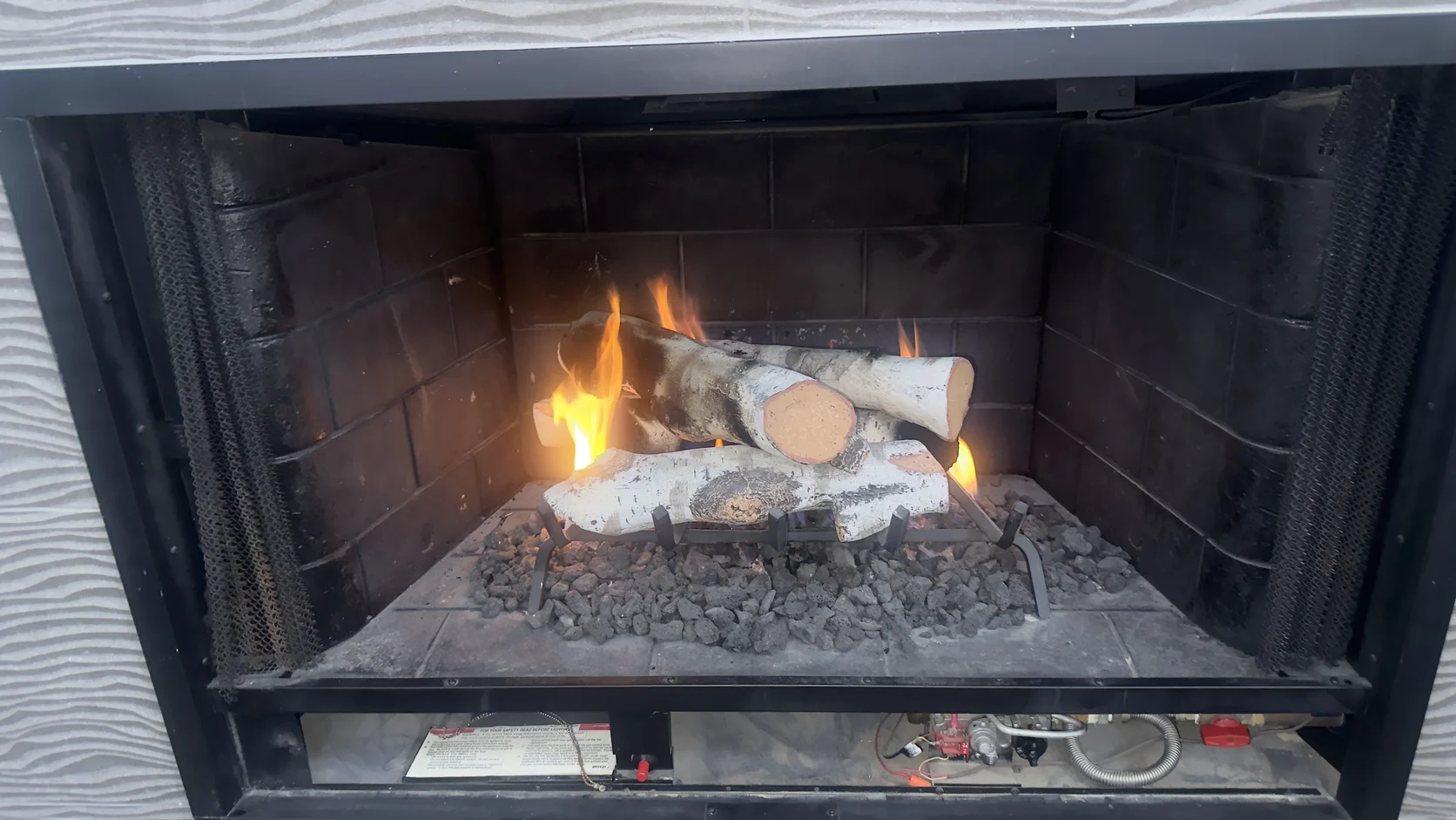 Lit gas logs in a black firebox