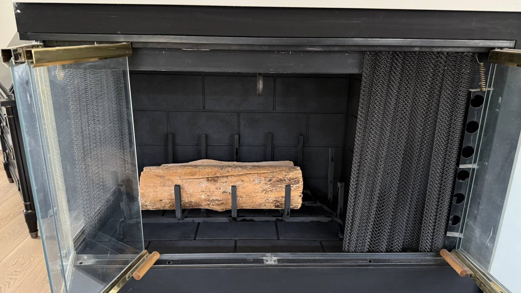 Firebox with glass doors open and a single log