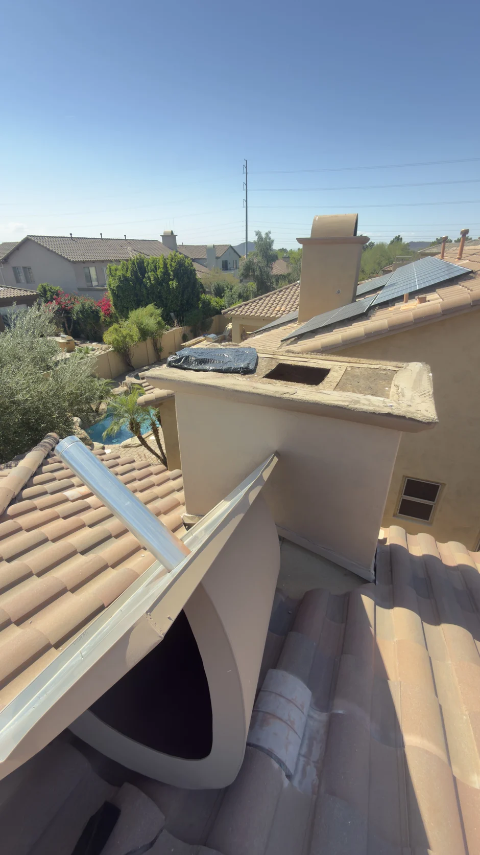 Rooftop chase cover above a barrel-tile roof