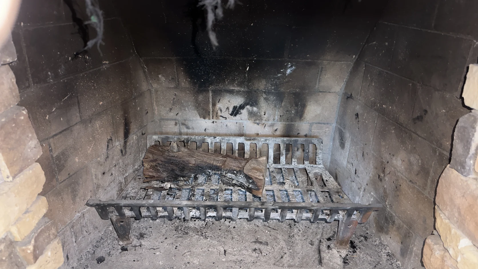 Interior of a masonry firebox with dark surface deposits