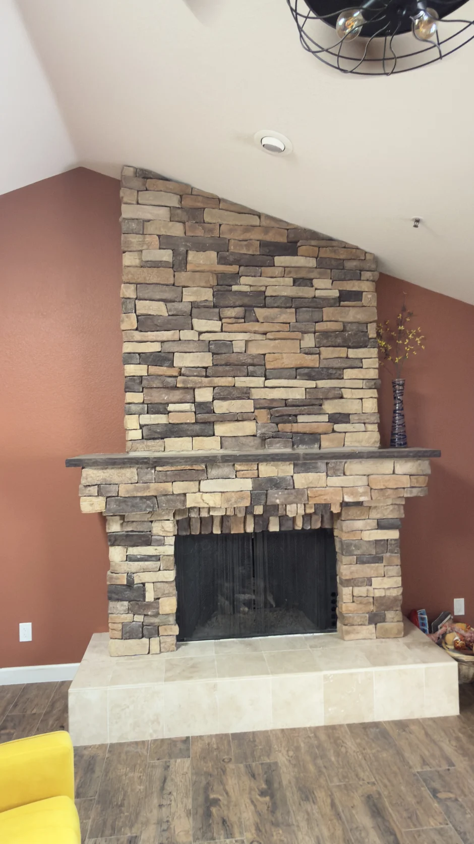 Stacked-stone fireplace in a red-walled room