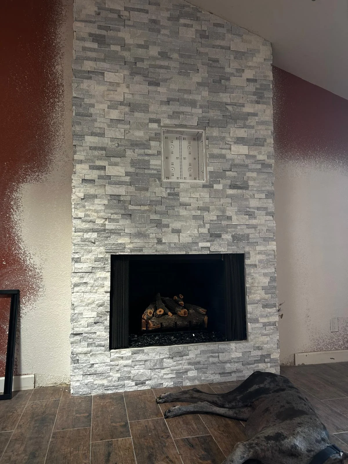 Lit insert in a stacked-stone fireplace wall