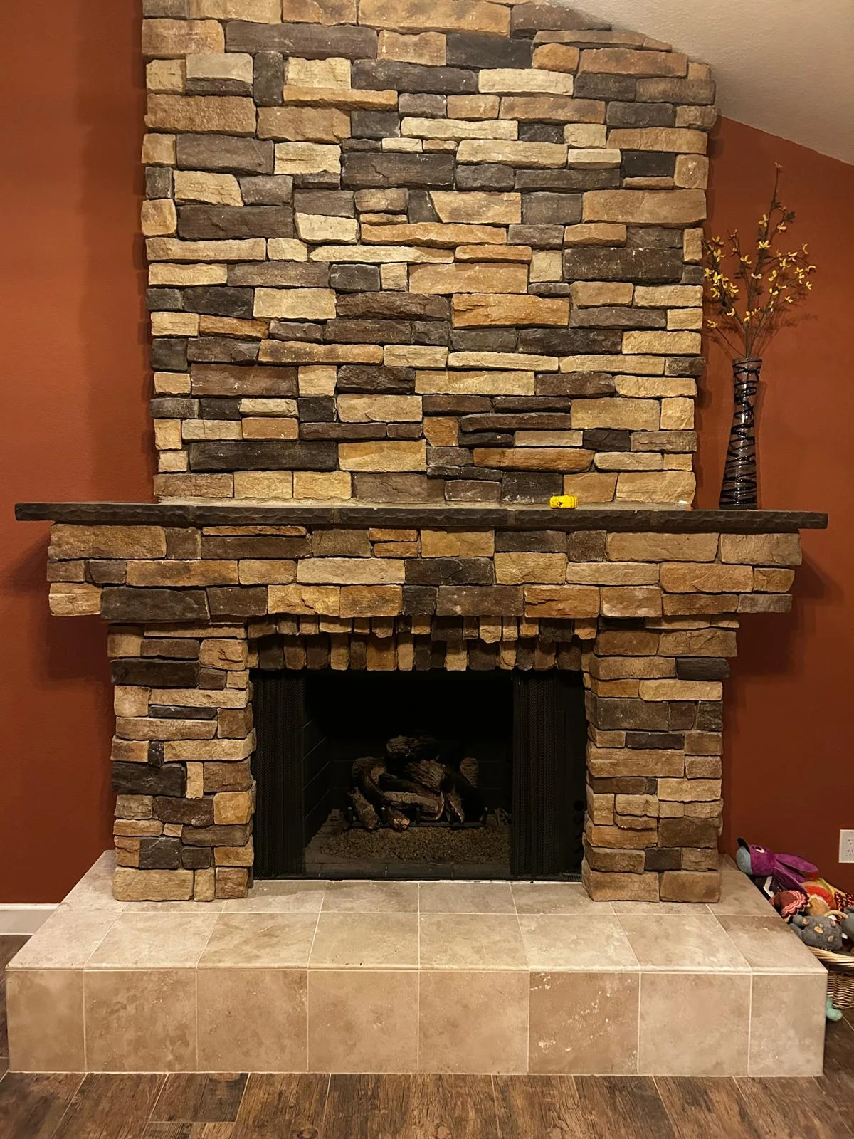 Full-height stacked-stone chimney wall in a red room