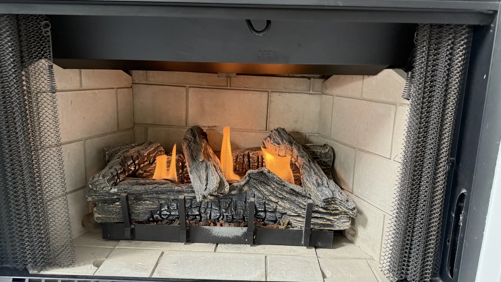 Lit gas logs in a stone-lined firebox
