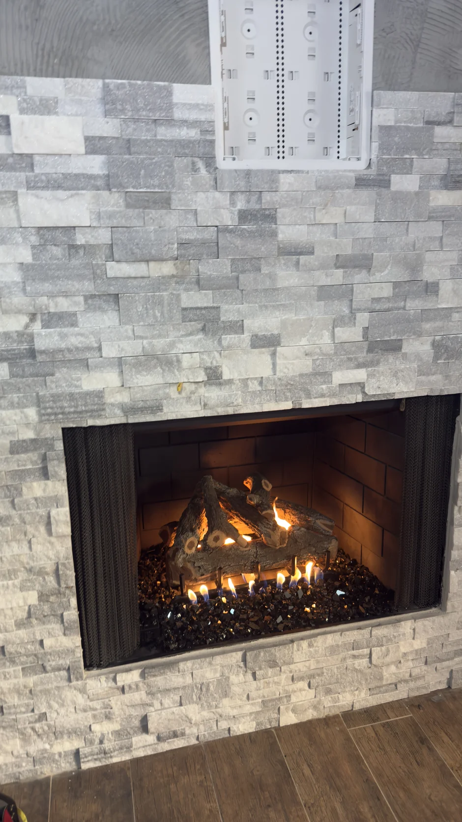 Fireplace insert in a stacked-stone wall