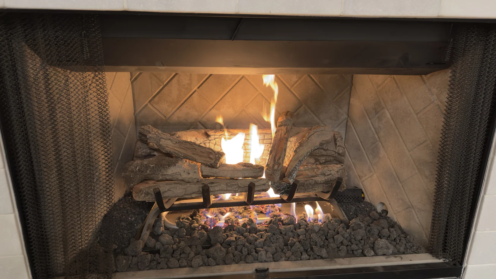 Lit gas logs in a tan refractory firebox