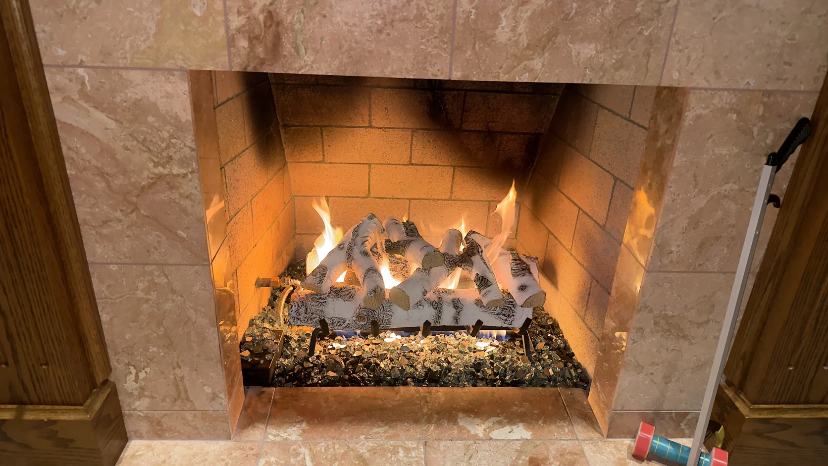 Lit fireplace with a travertine surround