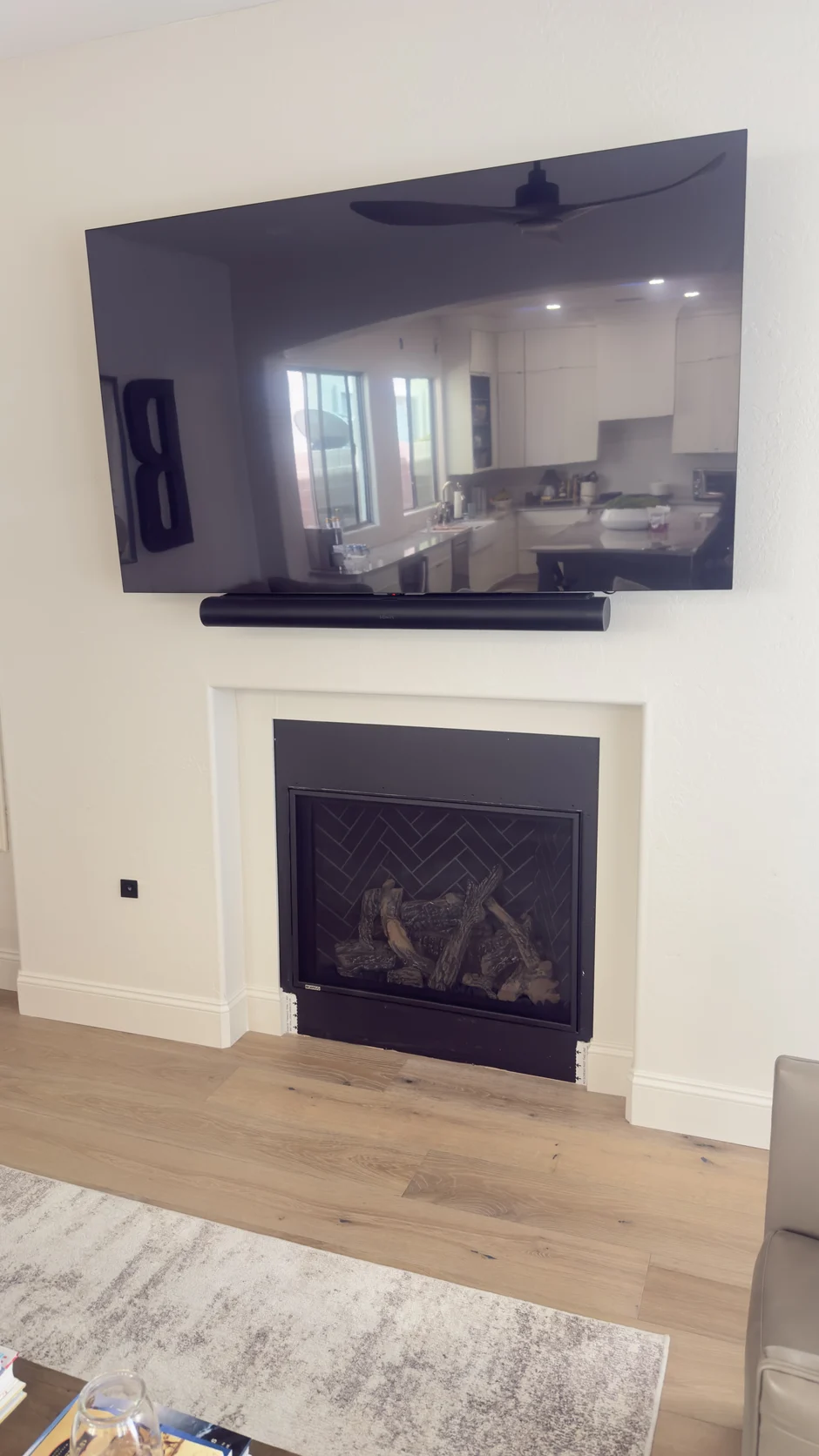 White fireplace below a wall-mounted television