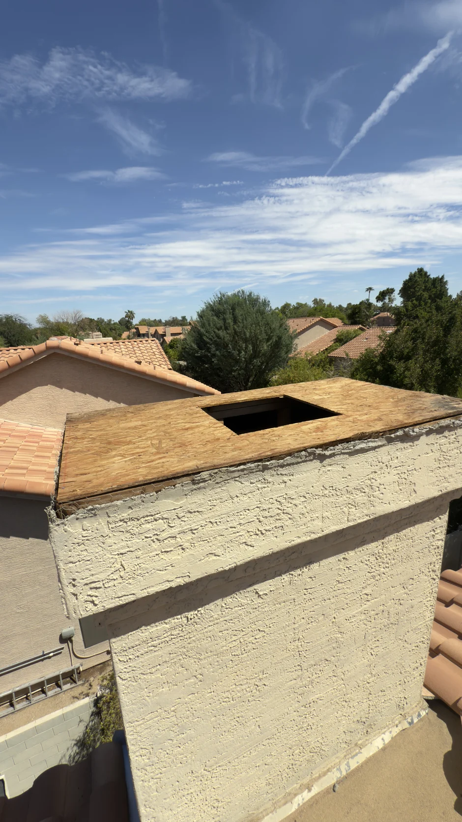 Uncapped clay flue standing open at the chimney crown before a cap is fitted