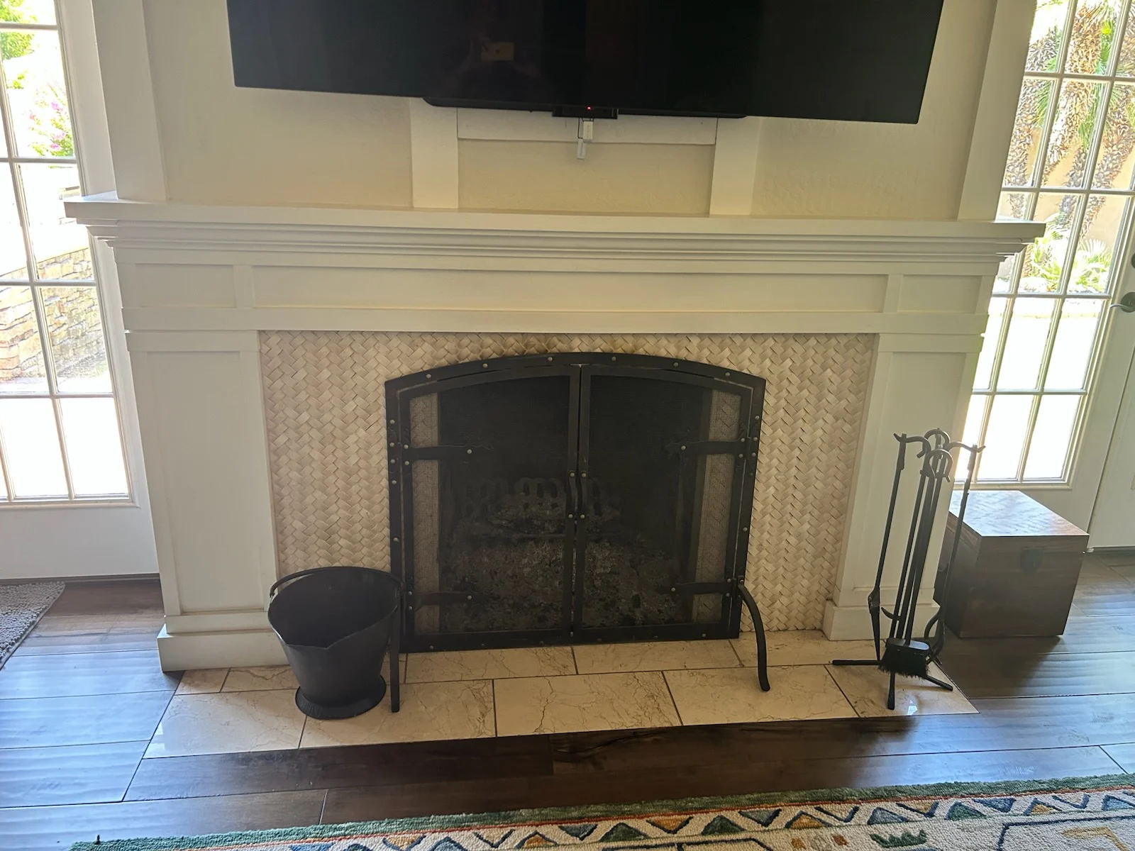 White mantel fireplace with a screen below a television