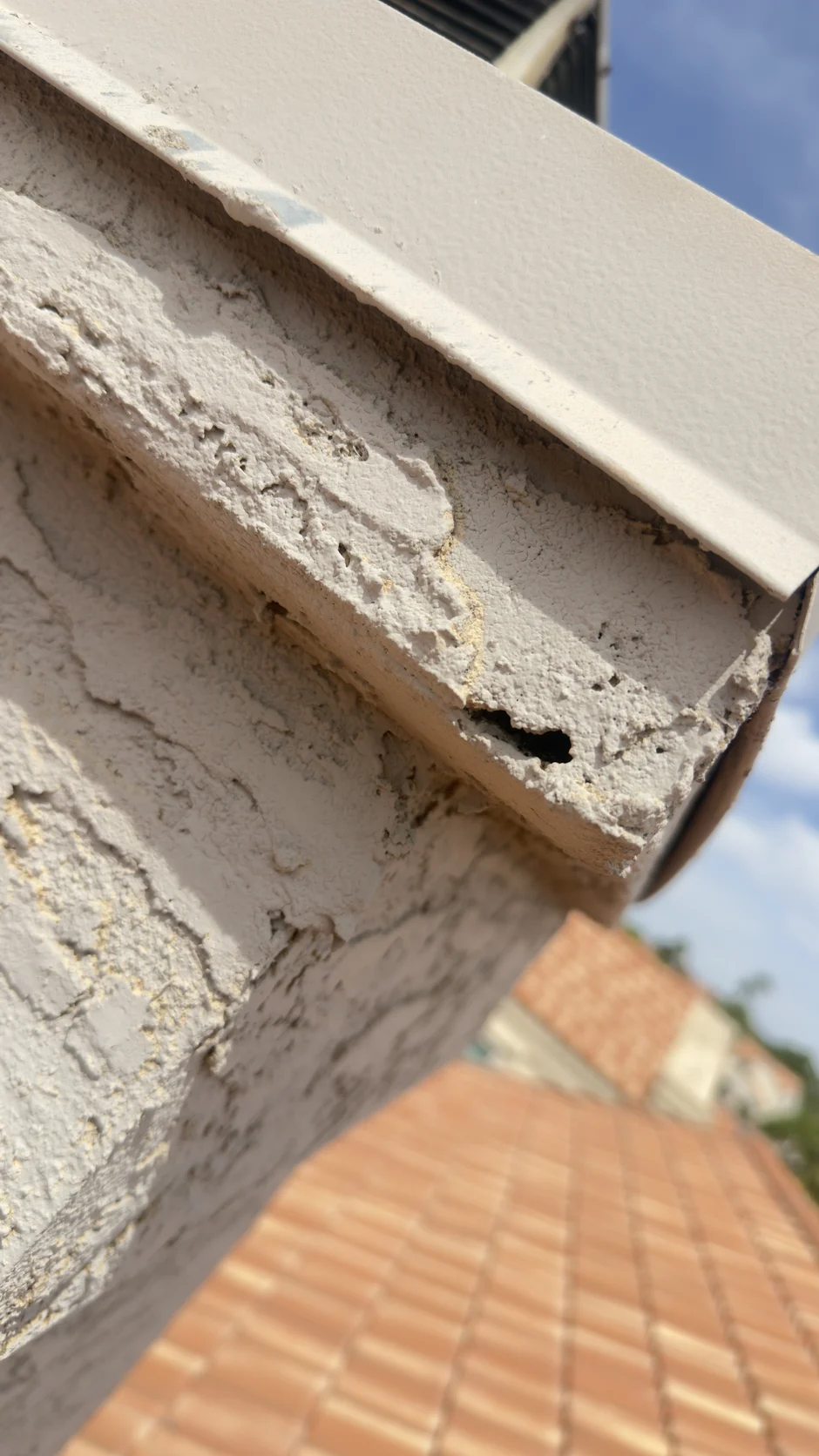 Close view of a worn, cracked chimney crown edge